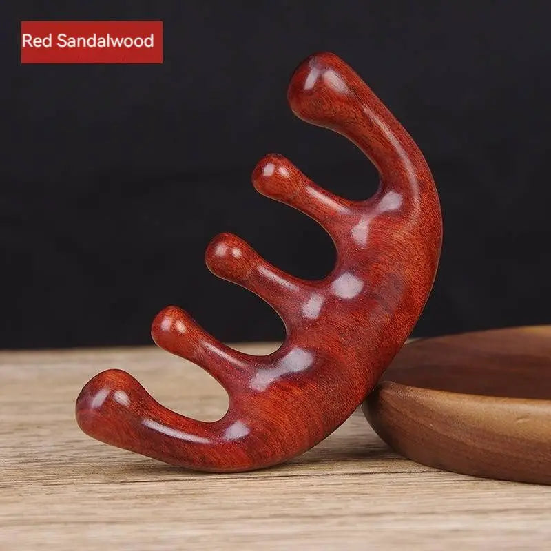 Massage Therapy Natural Wooden Massager Comb Red Sandalwood Colour with is 5 large wood teeth on a white wood table, leaning against a wooden circle