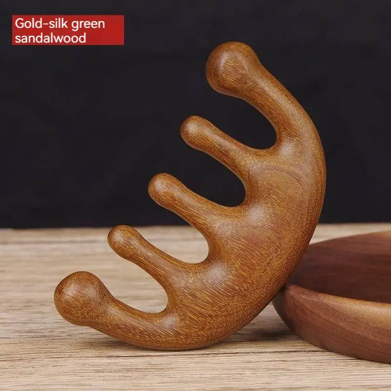 Massage Therapy Natural Wooden Massager Comb Gold-silk green Colour with is 5 large wood teeth on a white wood table, leaning against a wooden circle