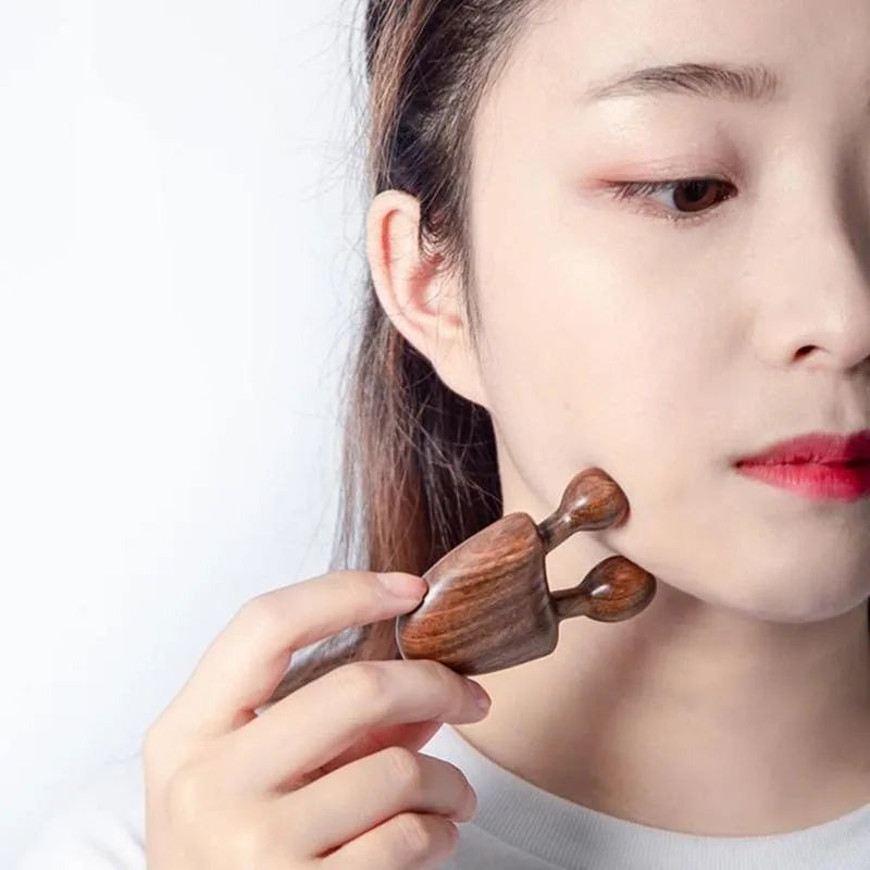 Jem Massage therapy:  A Woman using the wooden comb on her cheek skin picture