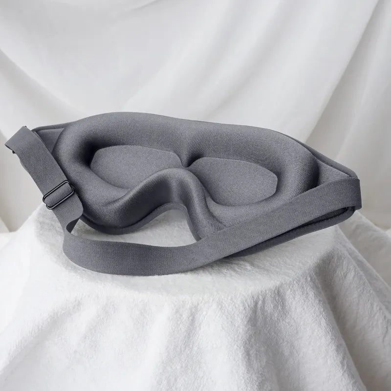 Jem Wellness Collection Soft 3D Sleep Mask for Light Blocking and Comfortable Rest gray Colour Offers shown Placed on a bed sheet