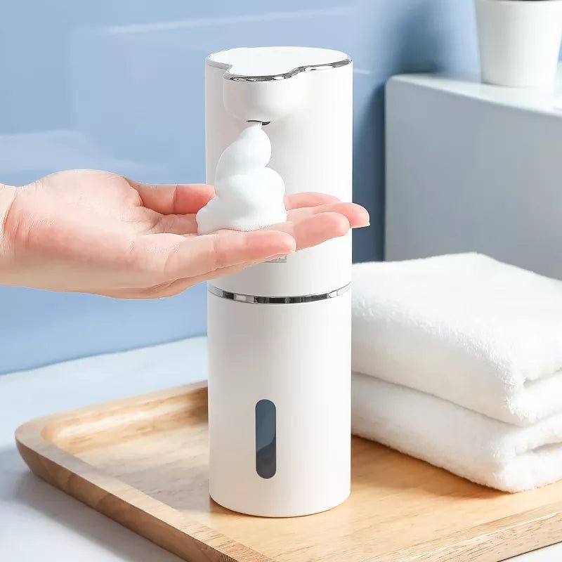 Wellness Automatic Foam Soap Dispensers White Colour offers in use by a woman hand displayed on a Wooden serving tray placed on a marble bathroom counter