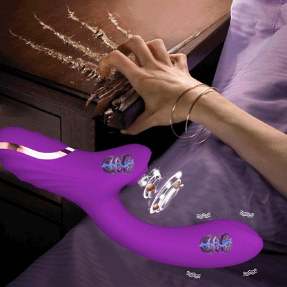 Wellness Clitoral Vibrator picture show a woman's hand scratching the top of a bedroom desk with her nails the Purple colour vibrator, NO storage box offers, clitoral vibration mode activated