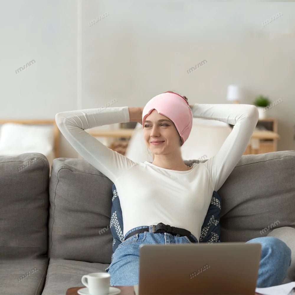 Wellness Head Massager Hot Cold Therapy Cap Gel Picture show a brown hair woman using the pink colour eye mask on her head sitting on a sofa in the living room in front of a lab-top